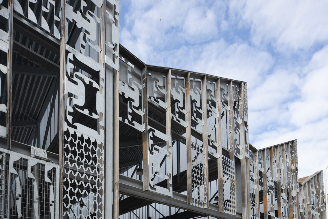 Gevel van een gebouw met metalen platen met gestanste figuren